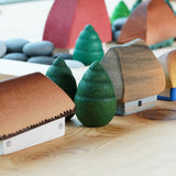 Bumbu Moldova handmade wooden miniature houses lined up on a wooden table next to some grapat mandala trees
