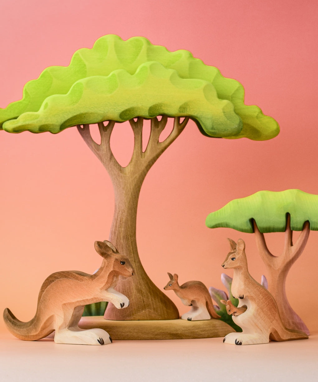 Bumbu Toys Mama Kangaroo & Joey figures set up in a small world lay scene along with other Bumbu toys.