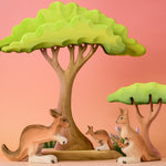 Bumbu Toys Mama Kangaroo & Joey figures set up in a small world lay scene along with other Bumbu toys.