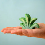 Bumbu mountain bush wooden toy figure for small world play in an adult's hand.