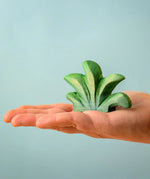 Bumbu mountain bush wooden toy figure for small world play in an adult's hand.