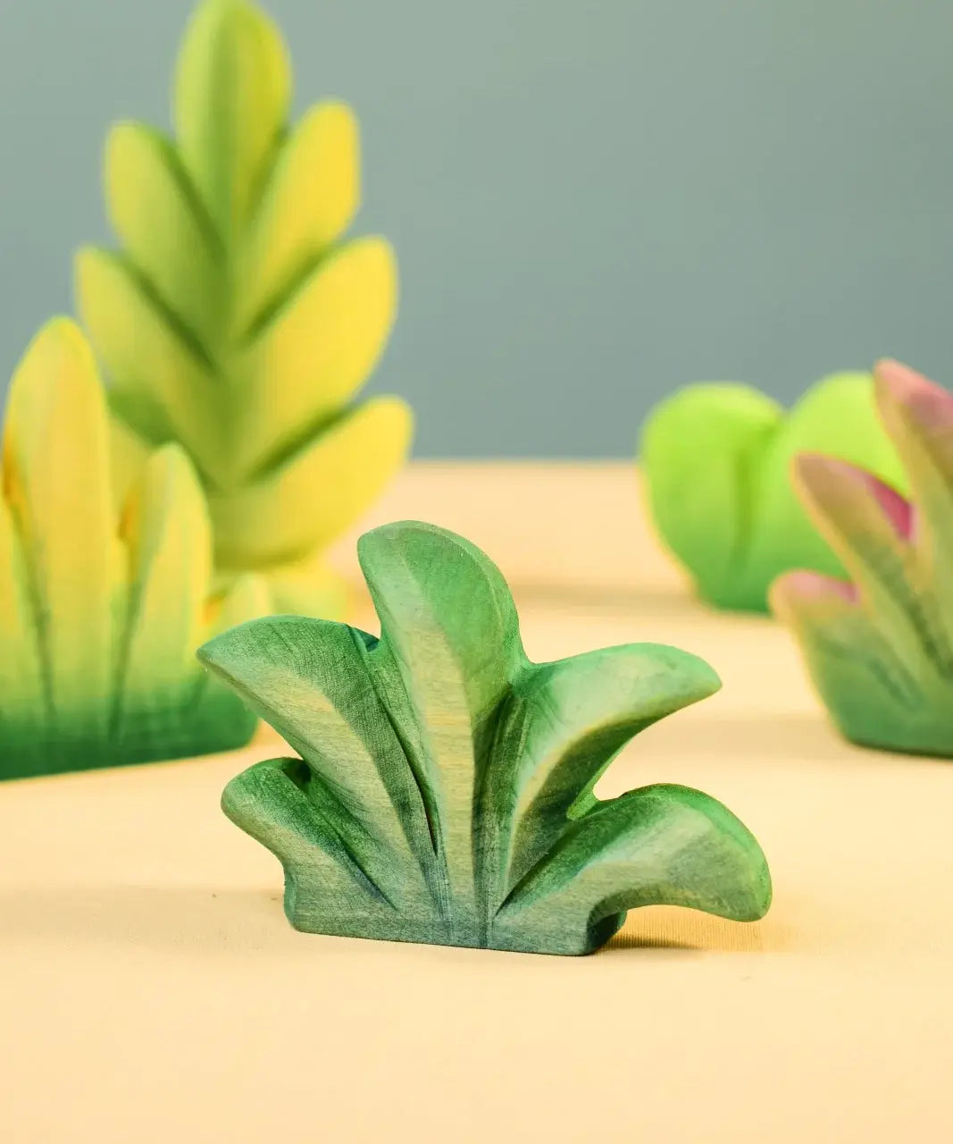 Bumbu mountain bush wooden toy figure for small world play with other bushed in the background.
