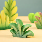 Bumbu mountain bush wooden toy figure for small world play with other bushed in the background.