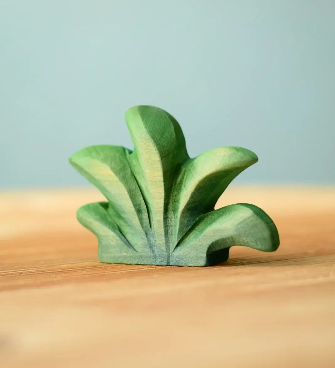Bumbu mountain bush wooden toy figure for small world play placed on a wooden surface.