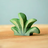 Bumbu mountain bush wooden toy figure for small world play placed on a wooden surface.