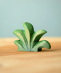 Bumbu mountain bush wooden toy figure for small world play placed on a wooden surface.