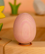Bumbu wooden pink egg decorative figure standing in a celebration ring