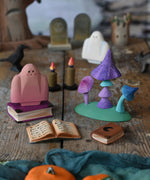 A pink Bumbu ghost placed in a small world play scene next to the Bumbu Wooden Enchanted Mushrooms Set. These expertly hand crafted items are part of a large range of wooden toys available here at Babipur. 