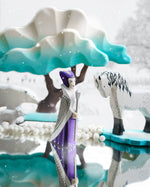 Bumbu wooden snow queen toy figure stood on a mirror next to a white horse figure and a Bumbu winter maple tree