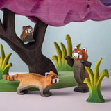 A family of the Bumbu red panda wooden figures in a nature play scene
