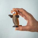  A hand holding the Bumbu playful red panda figure 