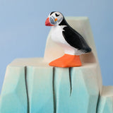 Bumbu Toys puffin handmade wooden toy figure placed on a wooden ice berg scenery piece.