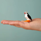 Bumbu Toys puffin handmade wooden toy figure on an adult's hand.