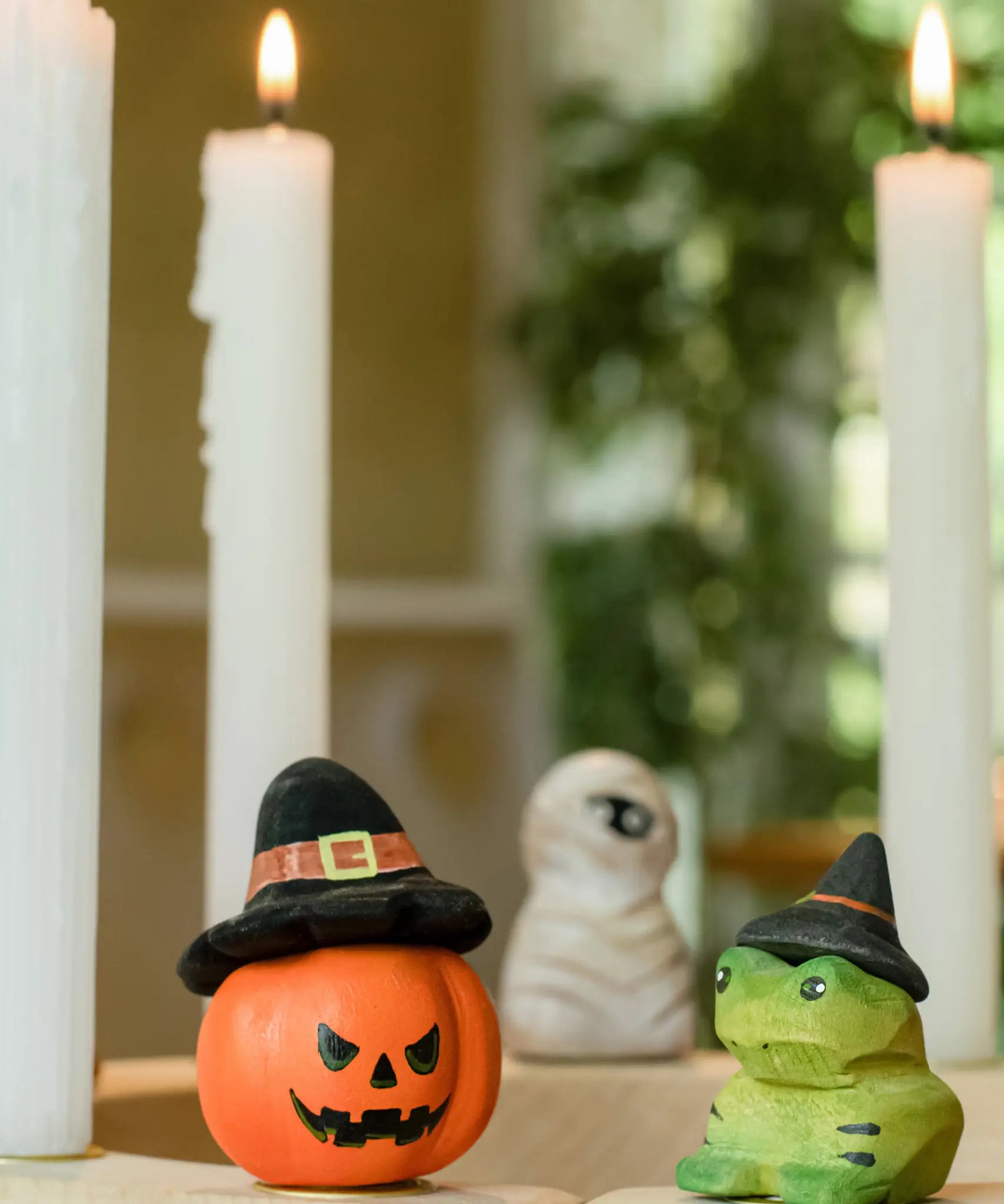 Bumbu pumpkin wizard and frog decorative figures placed on a natural wooden celebration ring. 