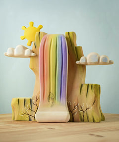 Bumbu Toys Rainbow Cliff placed on a wooden surface.