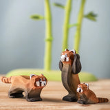 A family of the Bumbu wooden red pandas on a wooden board with the Bumbu bamboo in the background