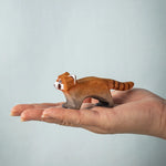 A hand holding the Bumbu red panda figure