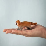 A hand holding the Bumbu red panda figure