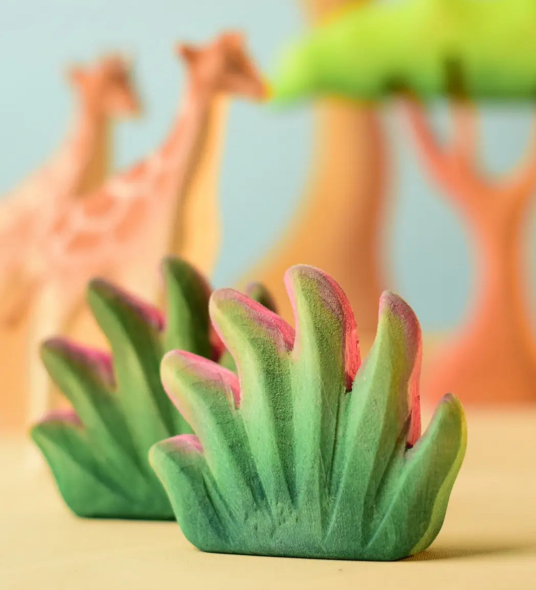 Bumbu Toys savanna bush wooden toy scenery figure placed in a small world play scene with giraffes in the background.