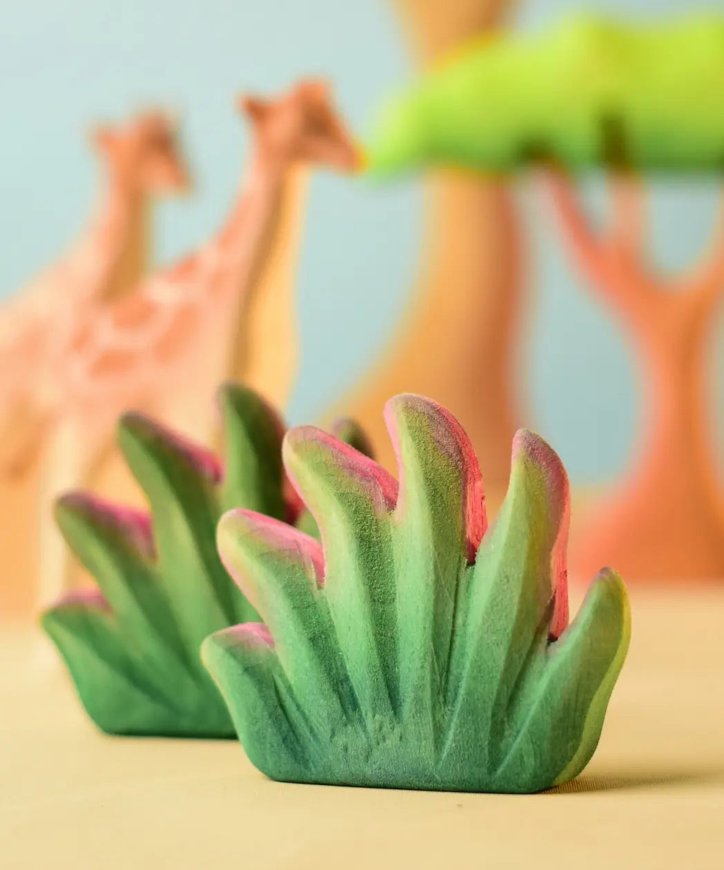 Bumbu Toys savanna bush wooden toy scenery figure placed in a small world play scene with giraffes in the background.