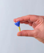 Bumbu blue small wooden flower wooden toy scenery in an adult's hand.