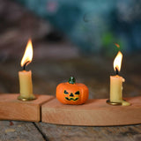 A small Bumbu Halloween figure placed on a wooden Grimm's celebration ring in between to lit candles.