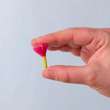 Bumbu Toys small wooden flower in pink in an adult's hand. 