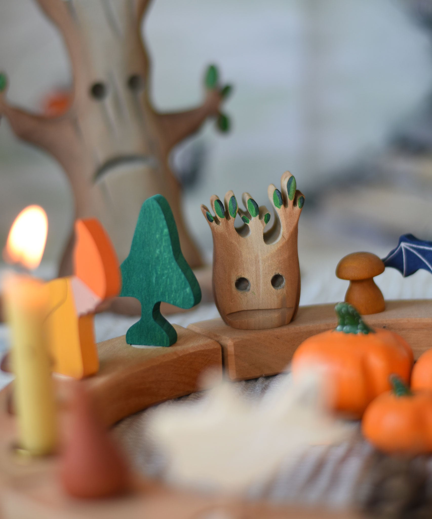 A small Bumbu spooky tree figure placed on a natural Grimm's celebration ring decorated with Halloween themed figures. 
