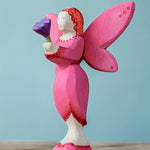 A Bumbu Small Wooden Flower in lilac shown placed in the blossom fairy's hands