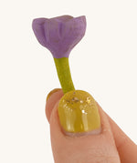Bumbu Small Wooden Flower in lilac being held up in front of a cream background
