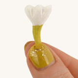 Bumbu Small Wooden Flower in white being held up in front of a cream background