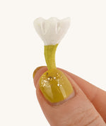 Bumbu Small Wooden Flower in white being held up in front of a cream background