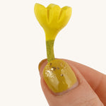 Bumbu Small Wooden Flower in Yellow bing held up in front of a cream background