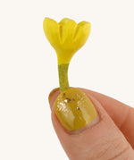 Bumbu Small Wooden Flower in Yellow bing held up in front of a cream background