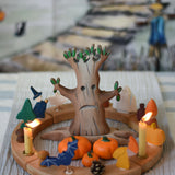 A large Bumbu spooky wooden tree figure placed in the middle of a Grimm's Halloween themed celebration ring set up. 