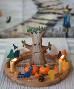 A large Bumbu spooky wooden tree figure placed in the middle of a Grimm's Halloween themed celebration ring set up. 