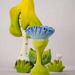 The Bumbu Toys Flama Spring Flower shown in front of a Bumbu birch tree an white flower. 