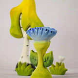 The Bumbu Toys Flama Spring Flower shown in front of a Bumbu birch tree an white flower. 