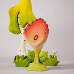 The Bumbu Toys Perla Spring Flower shown in front of a Bumbu tree and white flower. 