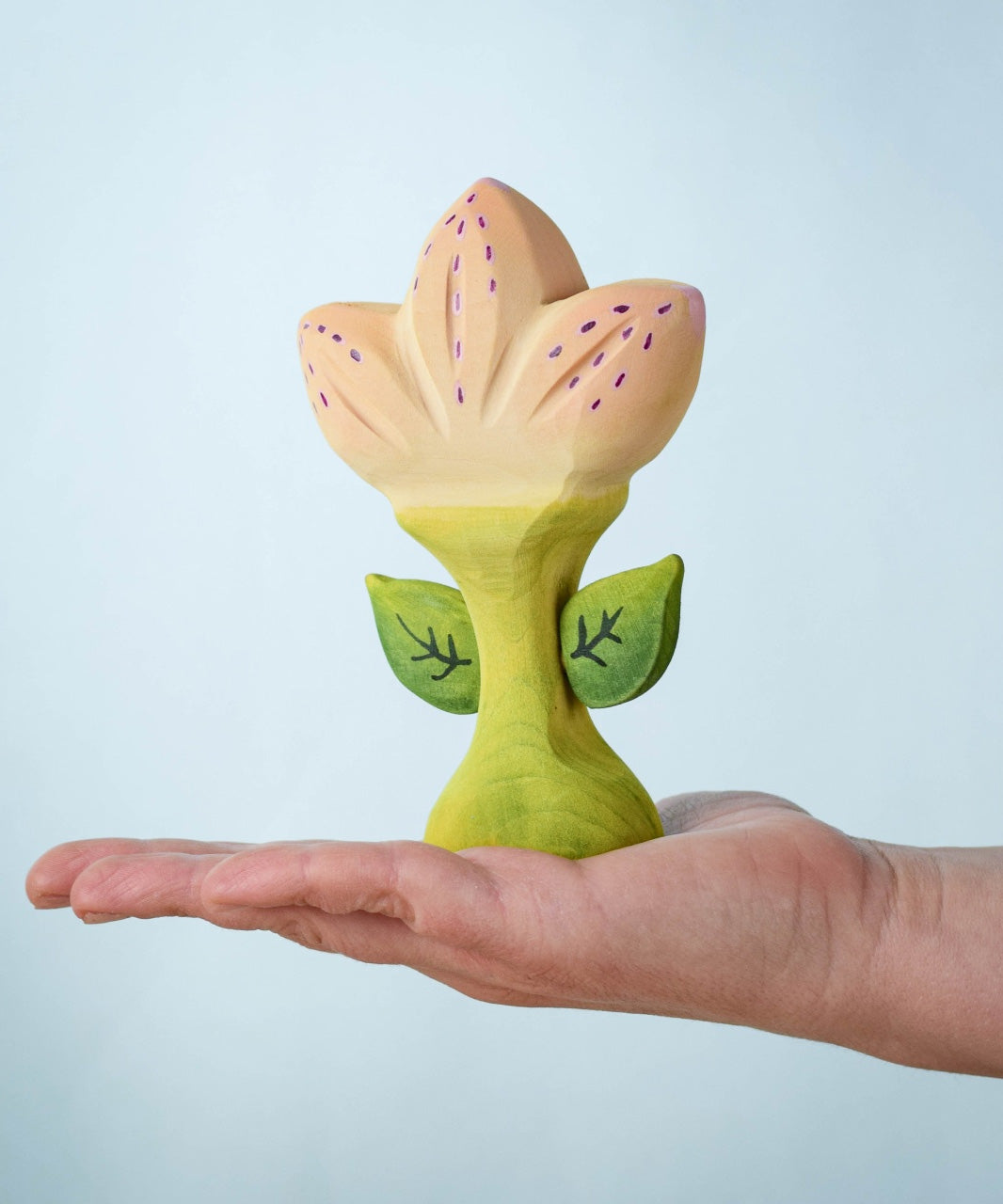 The Bumbu Toys Zia Spring Flower shown in an adult's hand.
