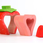 Pieces of the Bumbu eco-friendly wooden strawberry lined up on a white background