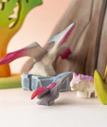 A Bumbu Toys Baby Pterandon placed at the front of a small world play scene with an adult Pterandon in the background. 
