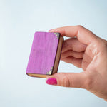 Bumbu Toys Large purple Book being held in an adult's hand. The person has pink painted fingernails.