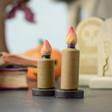 Bumbu Toys wooden Candle figures Set. The candles have a beige colour, on a black coloured base with a flame on the top. One candle is taller than the other. The candles are placed at the front and centre of a Halloween themed small world play set up. 
