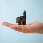 Bumbu Toys Scared Black Cat figure. The cat's tail is stood up and the cat has green eyes. The cat is balanced on a palm of an adult's hand. 