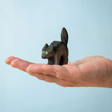 Bumbu Toys Scared Black Cat figure. The cat's tail is stood up and the cat has green eyes. The cat is balanced on a palm of an adult's hand. 