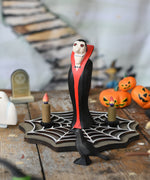 Bumbu Toys Dracula The Vampire Wooden Halloween Figure placed on a wooden cobweb in the middle of a small world play scene with Bumbu Halloween and Autumn themed toys.
These expertly hand crafted items are part of a large range of wooden toys available here at Babipur.  