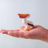 Bumbu Toys' Eating Pelican, being held in an adult's hand.