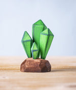 Bumbu Toys Green Crystals handmade wooden figure placed on a wooden surface. These crystals are part of a large range of wooden toys available at Babipur.
