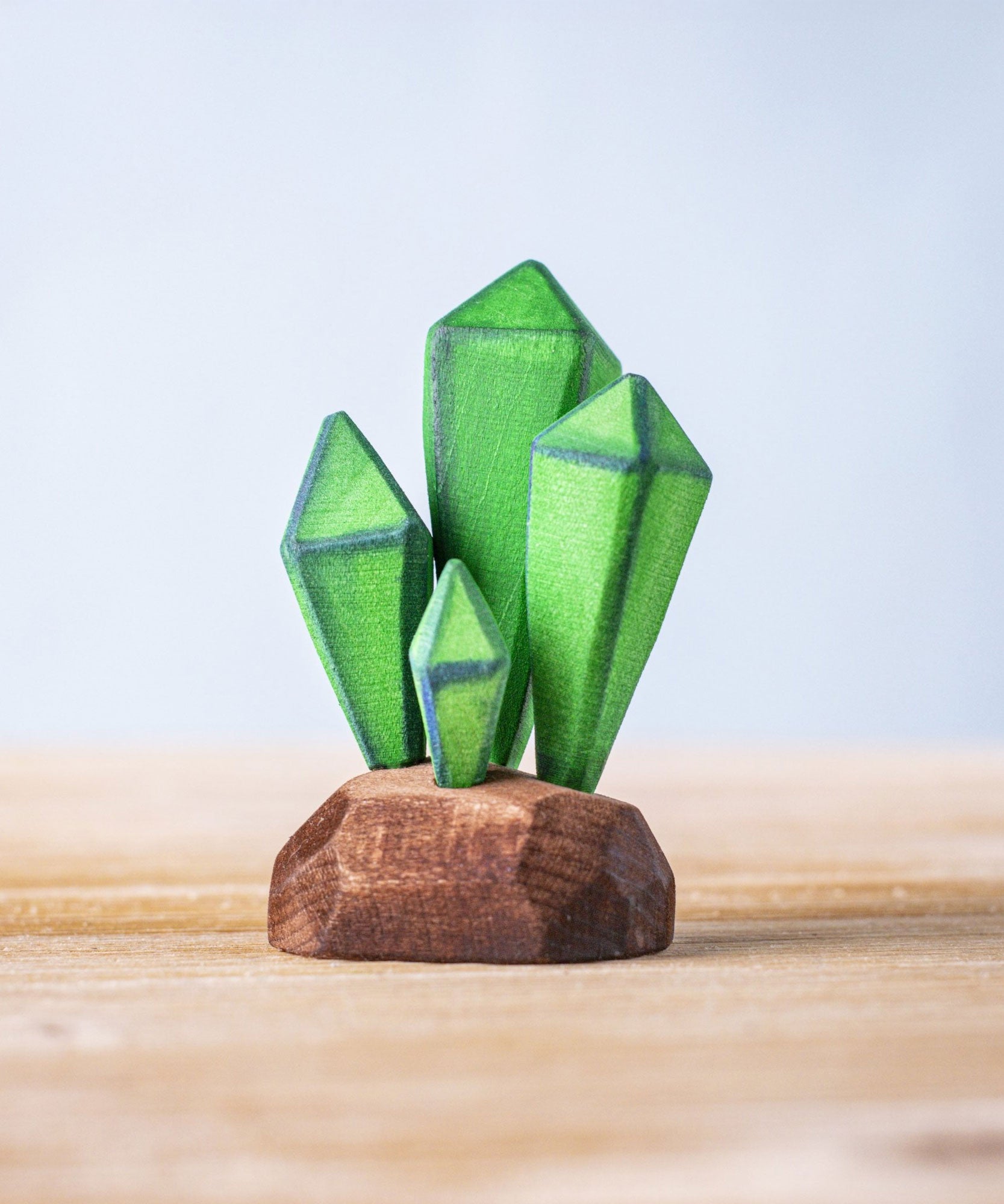Bumbu Toys Green Crystals handmade wooden figure placed on a wooden surface. These crystals are part of a large range of wooden toys available at Babipur.